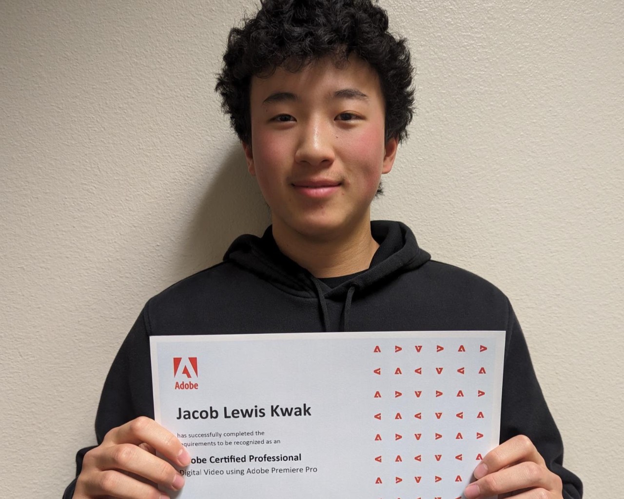 Jacob Kwak holding his Adobe Premiere Pro Certification certificate